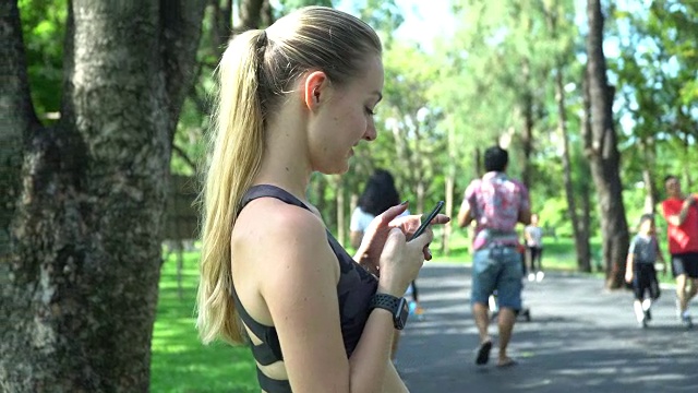 在公园里用智能手机的女人视频素材