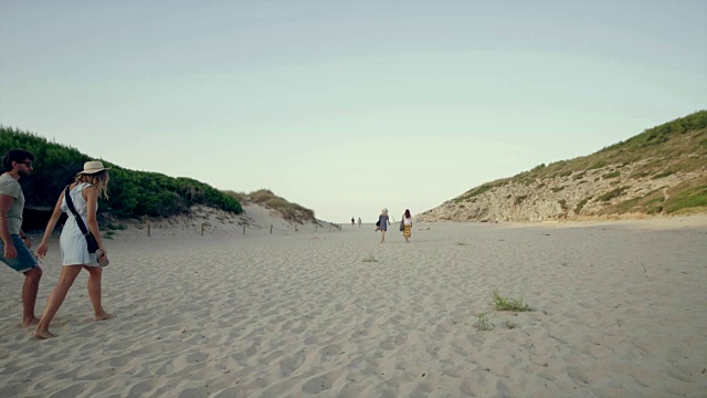 一对浪漫的情侣在海滩上散步视频素材