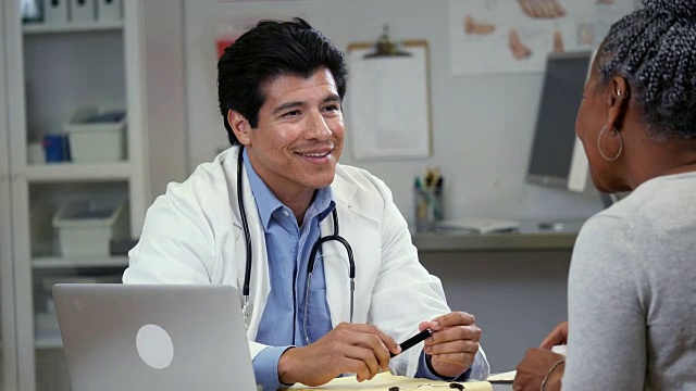 自信的中年西班牙裔男性医生与资深病人谈话视频素材