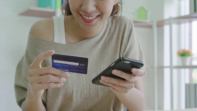 有魅力的亚洲女人用信用卡支付手机。视频素材