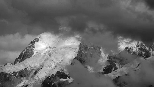 法国阿尔卑斯山，部分被快速流动的时间流逝风暴云遮蔽的雪山视频素材