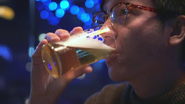 年轻人喝啤酒的特写，慢镜头视频素材