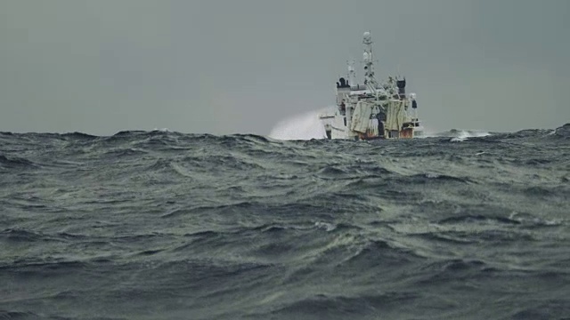 在波濤洶涌的海面上出海的拖網漁船視頻下載