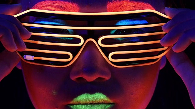 迷人的视频性感的网络raver女人拍摄在荧光衣服下的紫外线黑光。性感的女孩网络发光raver妇女拍摄在紫外线黑光下荧光服装，派对的概念视频素材