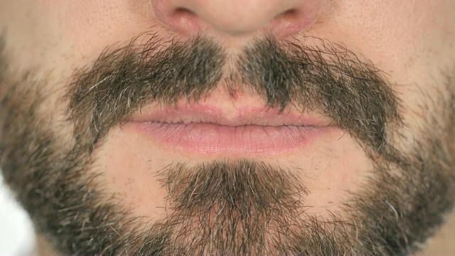 胡子男人微笑的嘴唇的特写，白色的背景视频下载