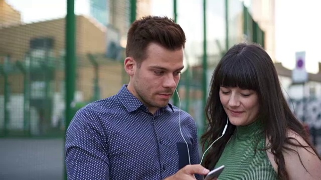 男人和女人共用耳机，听音乐。视频下载