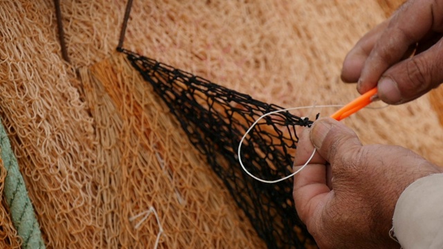 漁民用手用針修補漁網，特寫。視頻下載