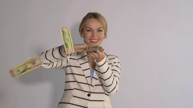 兴奋的成功女人扔钱。孤立在白色背景下，慢镜头视频素材