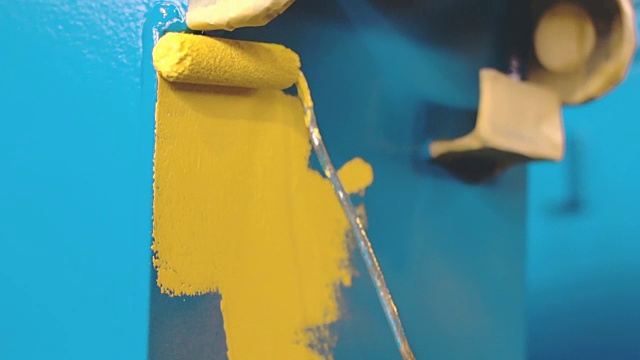 男子正在用手把蓝色的金属细节涂成黄色视频素材
