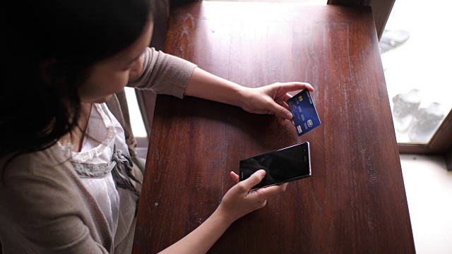 女商人用信用卡在手机上购物视频素材