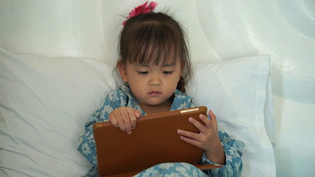 小女孩的肖像看他的平板电脑视频素材