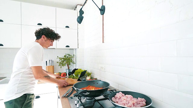 男在煎锅中准备鸡肉。视频素材