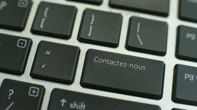 在电脑键盘上用法语按联系键，女性的手指按下按键视频素材