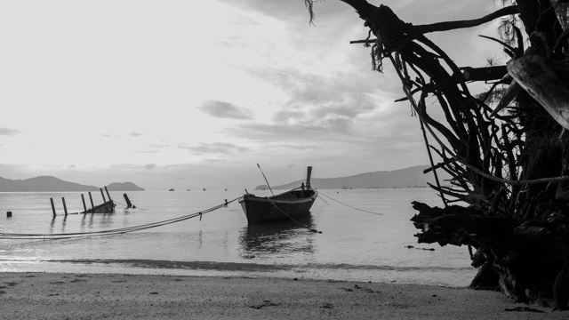 时间流逝日出或日落与长尾渔船在热带海洋上的黑色和白色调视频下载