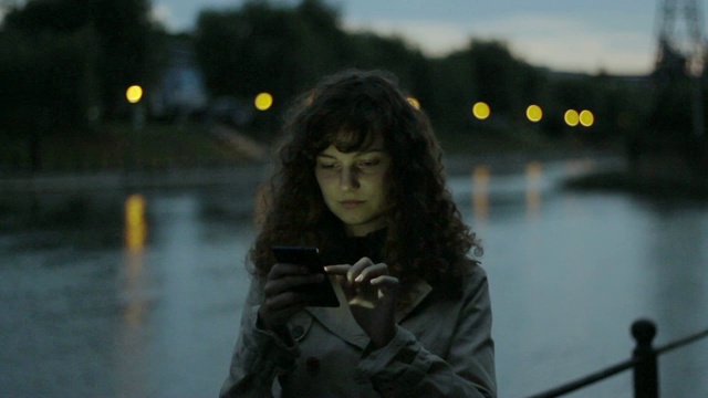 孤独的年轻女子使用她的智能手机视频下载