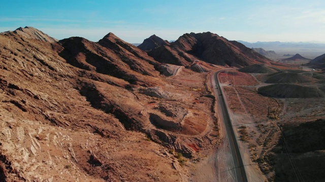 无人机拍摄的红色沙漠山脉旁边的湖米德路(道路进入和离开拉斯维加斯，内华达州)视频下载