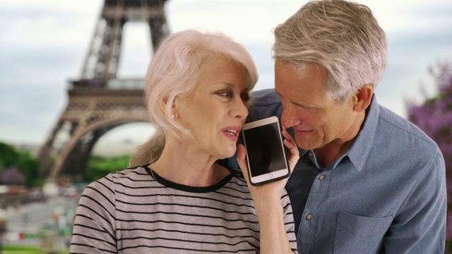 这是一对在巴黎打电话的快乐老年夫妇的肖像视频素材