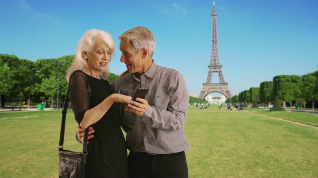 巴黎一对幸福的成熟夫妇使用智能手机的照片视频素材