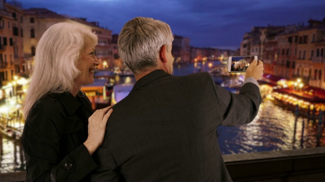 一对成熟的威尼斯夫妇在看他们智能手机上的照片视频素材