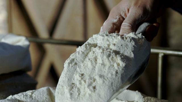 一个面包师的手从面粉袋里舀面粉的极端特写视频下载