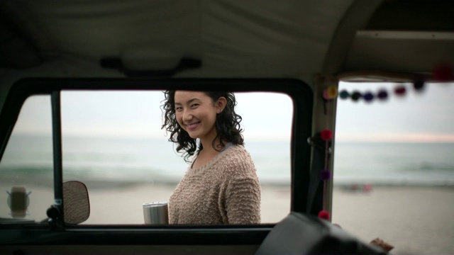 一名年轻女子开着露营车上路旅行视频购买
