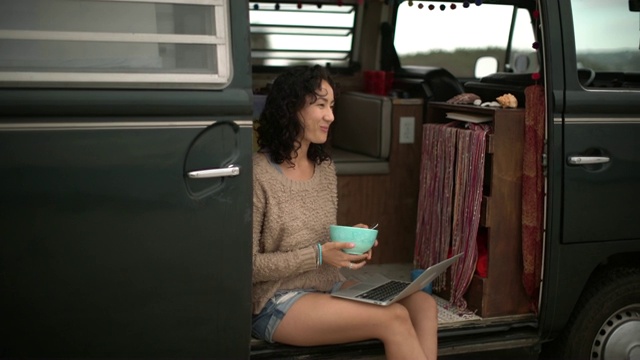 年轻女子在她的露营车里吃早餐视频购买