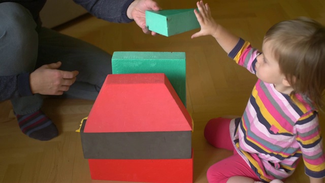 小女孩和爸爸用砖块建造玩具屋。儿童早期学习。培养关系视频下载