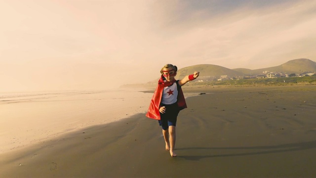 年轻的超级英雄女孩在加州海滩上跑步视频下载