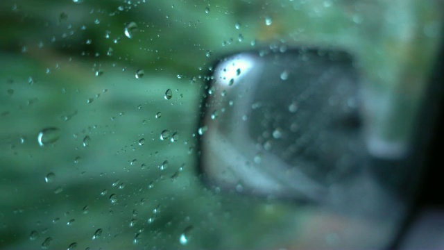 时间流逝水滴在窗户玻璃侧镜汽车背景在下雨。视频购买