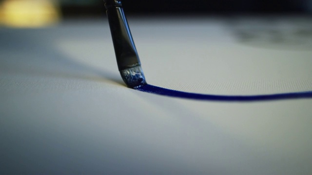 一个艺术家画一条细线的蓝色油画在画布上用画笔的特写镜头视频素材