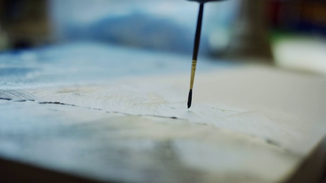 一个艺术家的特写应用油画画布使用一个小的画笔视频素材