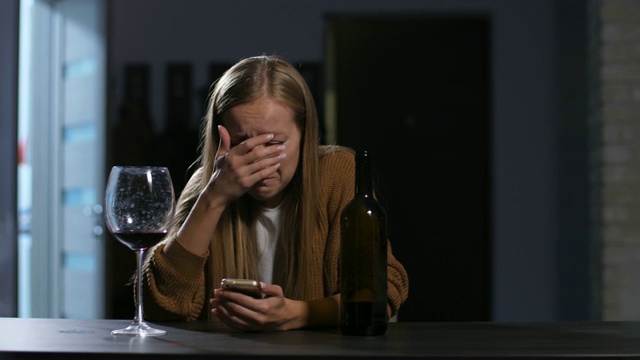 拒绝哭泣的女人在电话上读坏消息视频素材