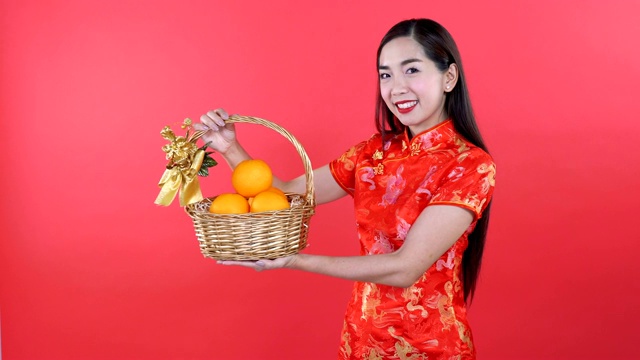 穿着旗袍的女人拿着篮子里的橙子视频下载