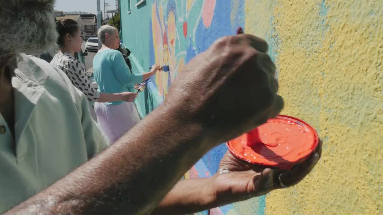 男子在阳光墙壁画上画心视频下载