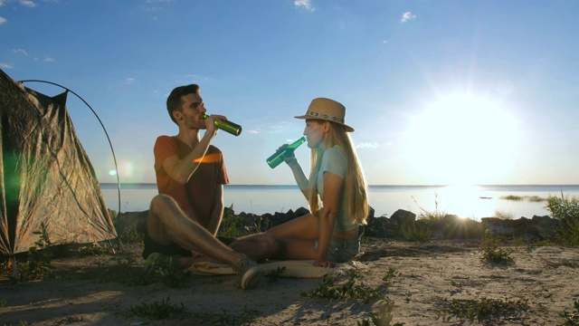 情侣们在露营时欢呼和喝啤酒视频素材