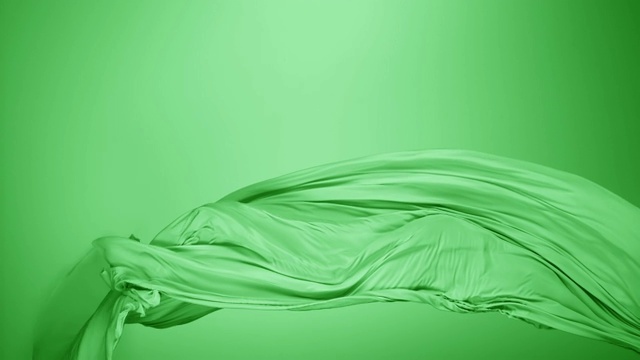 绿色丝质织物随风流动，绿色背景，慢镜头视频素材
