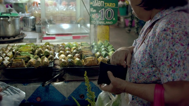 一位亚洲老妇人在农贸市场买泰国甜点视频下载
