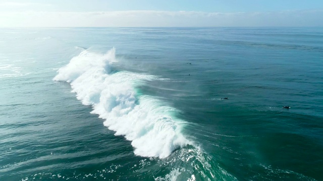巨大的蓝色海浪撞击在阳光明媚的一天的慢镜头鸟瞰图视频购买