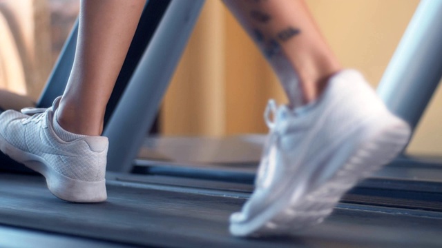 女人的腿在跑步机上跑步。锻炼，力量，训练-慢动作视频素材