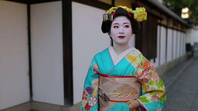 舞妓学徒在京都祗园的传统街道上行走视频素材