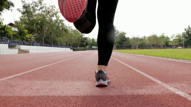 慢动作:女跑步者在跑道上跑步，腿靠近视频素材