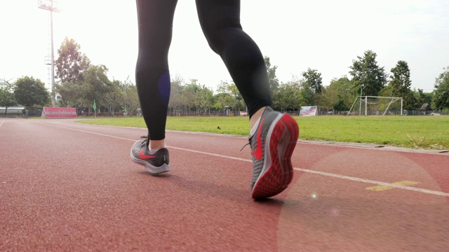 慢动作:女跑步者在跑道上跑步，腿靠近视频素材