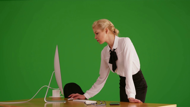 白人女商人站在绿色屏幕上的电脑前工作视频下载