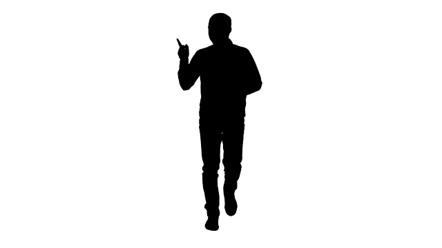 剪影一个年轻自信的男人，穿着衬衫和牛仔裤走向相机，指着两边视频素材
