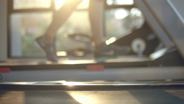 分散注意力:年轻女子在健身房的跑步机上锻炼和慢跑视频素材