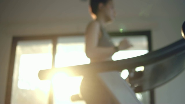 分散注意力:年轻女子在健身房的跑步机上锻炼和慢跑视频素材