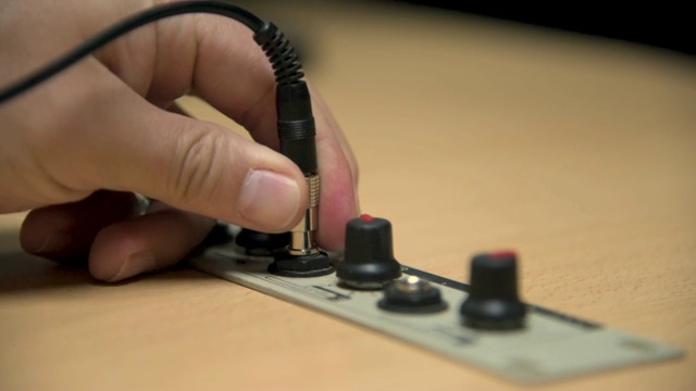 将耳机插孔插入电台播音室并调节音量的手视频素材