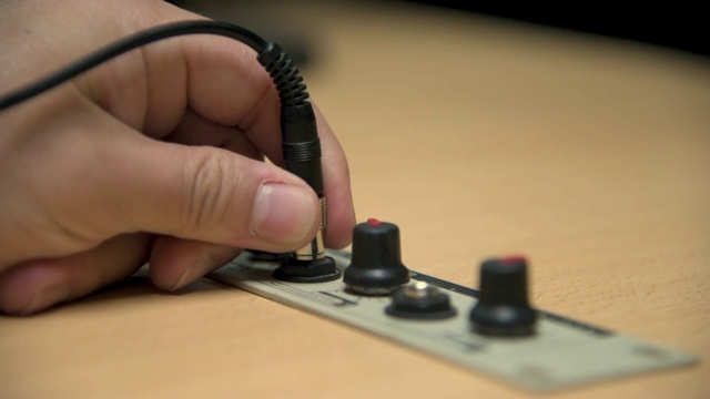 一只手把耳机插孔插进广播电台的演播室视频素材