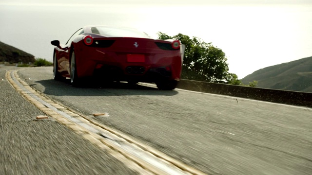 红色法拉利沿着马里布峡谷行驶，背景是太平洋视频素材