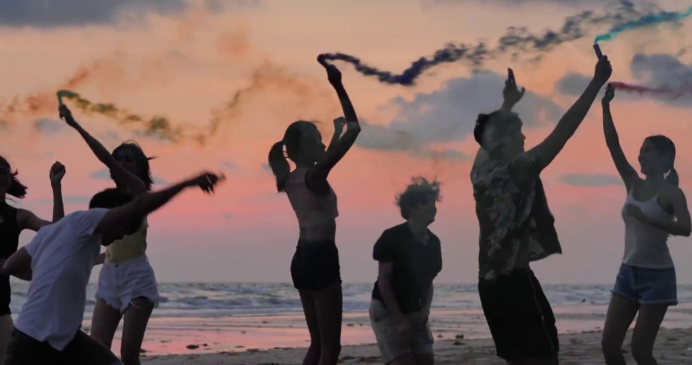 一群朋友的剪影在海滩上玩烟花视频素材